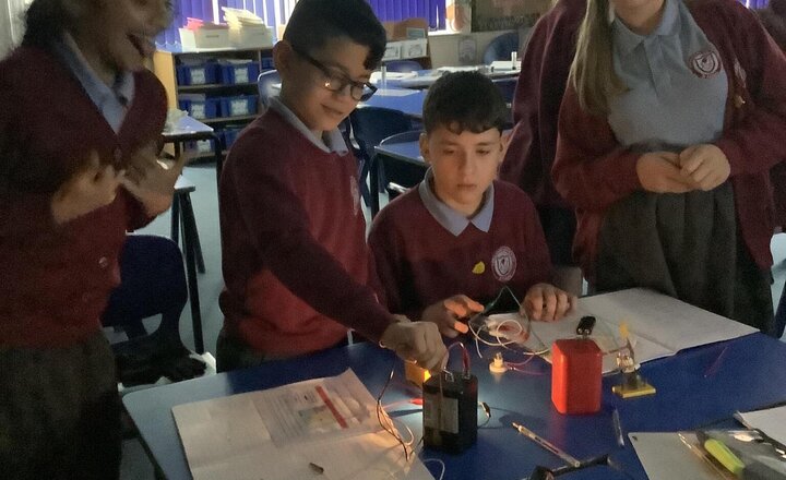 Image of Investigating what happens to the bulbs when more voltage is added. Well done year 6.